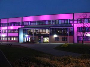 Supporting image for story: Students look at the Reclaim These Streets message as their school is lit up 