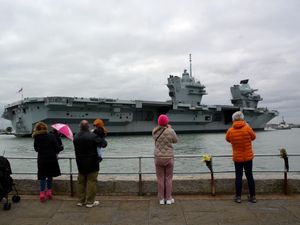 Members of the public watch as HMS Prince of Wales returns to Portsmouth Naval Base