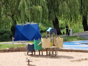 A tent was seen between the river and the children's play area