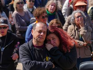 People watch a live broadcast from the funeral of slain hostages Shiri Bibas and her two children, Ariel and Kfir, at a plaza known as the Hostages Square in Tel Aviv