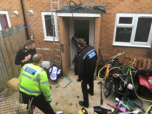 An officer smashes the door before officers enter the property