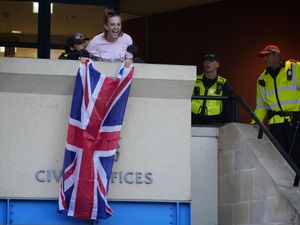 Supporting image for story: Charges dropped against woman who unfurled flag from Epping council building