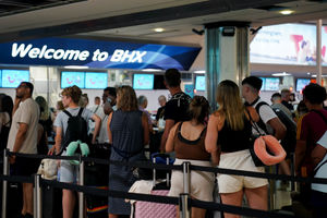 Passengers queue at Birmingham Airport