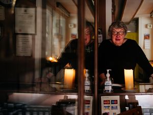 Supporting image for story: Oswestry shop stays open by candlelight after flood-induced power cut divides street