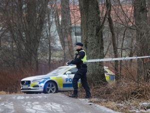 Police officer puts up police tape