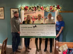 Robert Hamlett, Emily Hamlett, Joanna Williams, and Faye Dickson are pictured presenting a cheque to a representative from the Motor Neurone Disease Association.