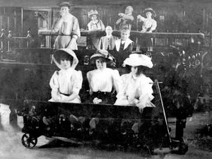 Members of the Parr family try the stocks for size at the Guildhall in Much Wenlock in 1898.