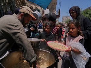 Supporting image for story: Palestinians block and empty dozens of UN food lorries in Gaza Strip