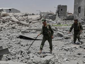 Yemeni soldiers inspect the damage reportedly caused by US airstrikes in Sanaa, Yemen on Sunday