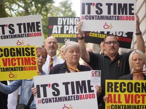 Infected blood campaigners holding placards