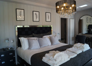 The master bedroom has a huge bed and a free-standing bathtub.