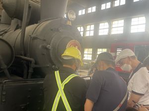 Engineers from the Alishan Forest Railway show Welshpool railway company secretary Michael Reilly (right) around one of the distinctive steam locomotives during his visit to their HQ in Chiayi, Taiwan. Photo: Mal Tattersall