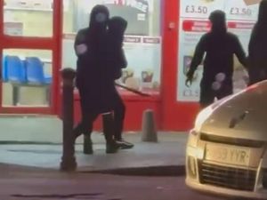 Two men fighting with machetes in the street outside a fried chicken shop on Witton Road, in Aston, Birmingham. 