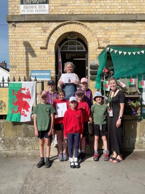 New Radnor Primary School pupils and shop owner Sharon Harris outside Esco's shop, where they taught people Welsh
