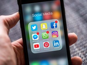 Social media app icons displayed on an Apple iPhone