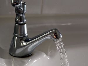 A general view of water dripping out of a kitchen tap.