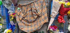 A burberry shirt signed by wellwishers was pinned to the fence