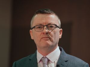 Head and shoulders photo of David Cullinane, wearing a suit and tie and glasses