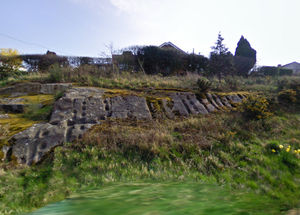 This image from Google Street View shows the sandstone face has become somewhat moss-covered and overgrown