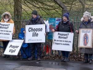 People holding placards reading 'Choose life' and 'Prayer vigil'