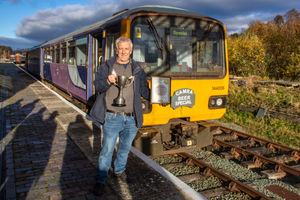 Dave Ricketts with the Cup and certificate in front of the CAMRA Beer Special (Ex-BR Pacer 144006 in Northern Rail livery)