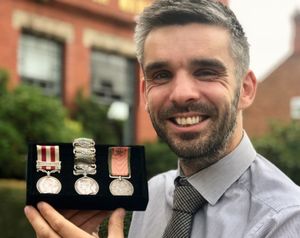 Auctioneer Aaron Dean with the Crimea Light Brigade medal group which sold for £2,500.
