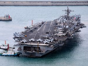 The USS Carl Vinson aircraft carrier is escorted into a navy port in Busan, South Korea, on Sunday