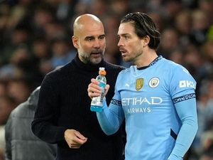 Manchester City substitute Jack Grealish alongside manager Pep Guardiola