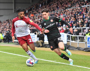 Walsall's Isaac Hutchinson gets past Northampton's Akin Odimayo