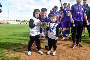 Matty Stenson with his sons after AFC Telford United players and staff lift the Southern Central Premier play-off trophy in front of fans after beating Kettering Town 4-2 at Latimer Park (Picture: Kieren Griffin Photography)