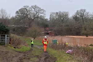 Officials near the field which was flooded by the canal breach.