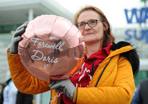 Staff member Joanne Holloway pays her respects outside Asda