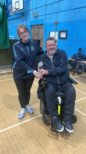 Ian Martin MBE presenting Briony with the Ian Martin award for disability inclusion in cricket. 
