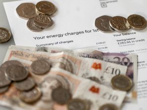 Money is stacked on top of an energy bill.