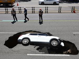 Supporting image for story: Driver and passenger injured as car is swallowed up by sinkhole