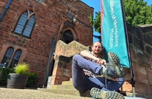 Dr Robert MacKinnon from the Soldiers of Shropshire Museum putting on his walking boots outside Shrewsbury Castle.