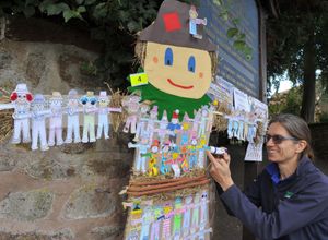 Sue Ray, from Edgmond Hall Centre For Outdoor Learning, sticking on a coloured mini scarecrow which visitors helped to make