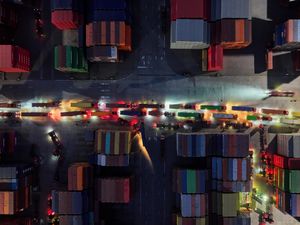 Trucks line up to depart from a container terminal in Nanjing in east China’s Jiangsu province