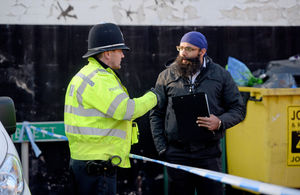 Police speak with bystanders as the investigation continues 