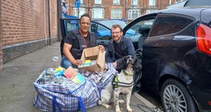 Mohammed Tariq, Senior Trading Standards Officer and Councillor Jamie Tennant, Cabinet Member of Social Justice, Community Safety, and Equalities, with large bags of seized goods