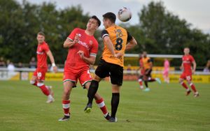 Walsall's Oisin Mcentee goes up for a header with Leamington's Adam Walker