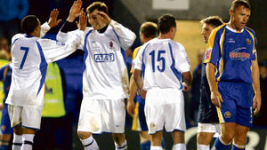 A dejected Graham Coughlan of Shrewsbury Town walks off at the end of the match as Staines Town celebrate their win (AMA)