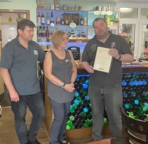 CAMRA chairman Mark Hewitt presenting Keg and Comfort owners John and Louise Clive with their certificates