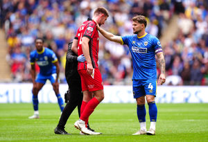 Walsall's Harry Williams is consoled by AFC Wimbledon's Jake Reeves (right) after being helped off the pitch due to an injury during the League Two play-off final at Wembley