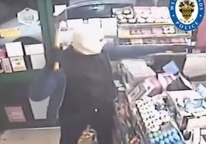 One of the men threatens the worker with an axe