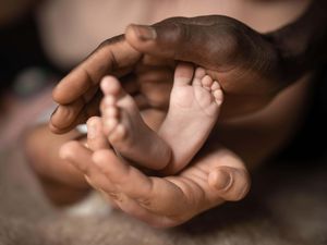 A parent holding a baby's feet