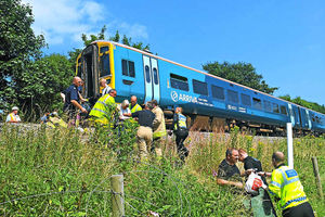 Rescue workers help passengers leave the stricken train after the collision with the tractor and trailer