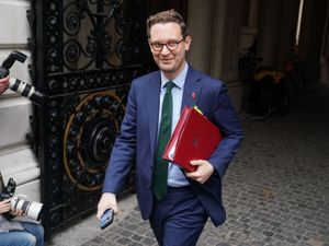 Darren Jones smiling while walking with his ministerial folder under his arm