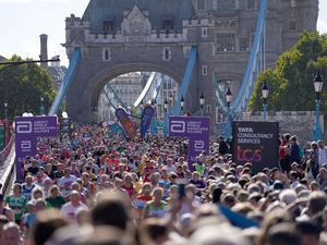 A crowd of London Marathon runners on Tower Bridge