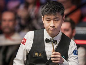 Zhao Xintong sizes up a shot